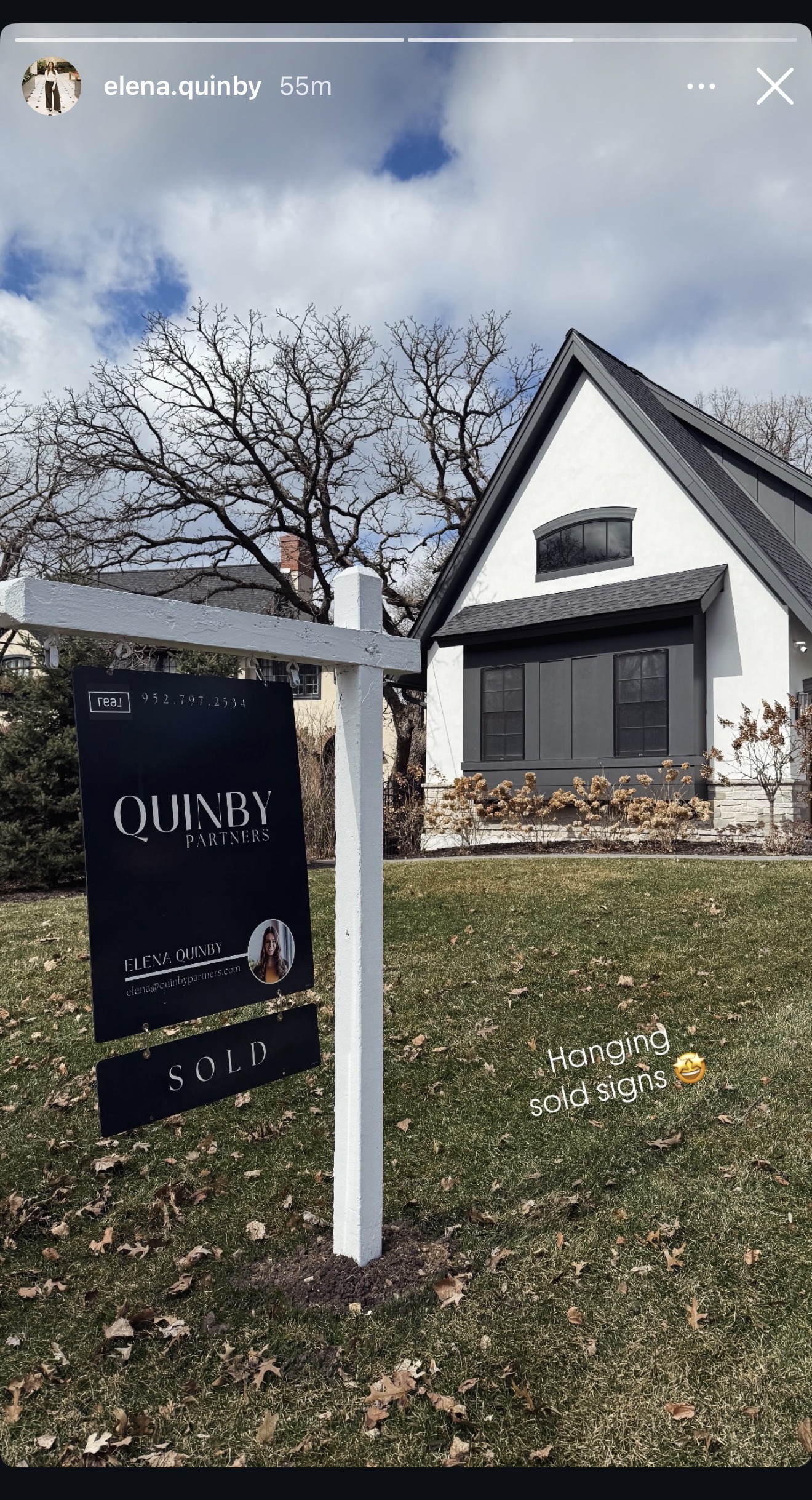 Elena Quinby hanging a Quinby Partners SOLD sign at a Minneapolis listing.